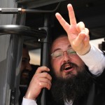 An Ultra Orthoxo gestures victory with his hands after boarding the bus outside the Supreme Court of Jerusalem.