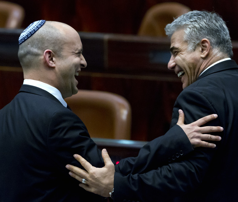 File photograph shows Israeli Finance Minister Yair Lapid (R) with Naftali Bennett, Economy Minister and Chairman of the right-wing Habayit Hayehudi (Jewish Home) party, as they confer on the floor of the Knesset (Parliament) in Jerusalem. EPA/JIM HOLLANDER