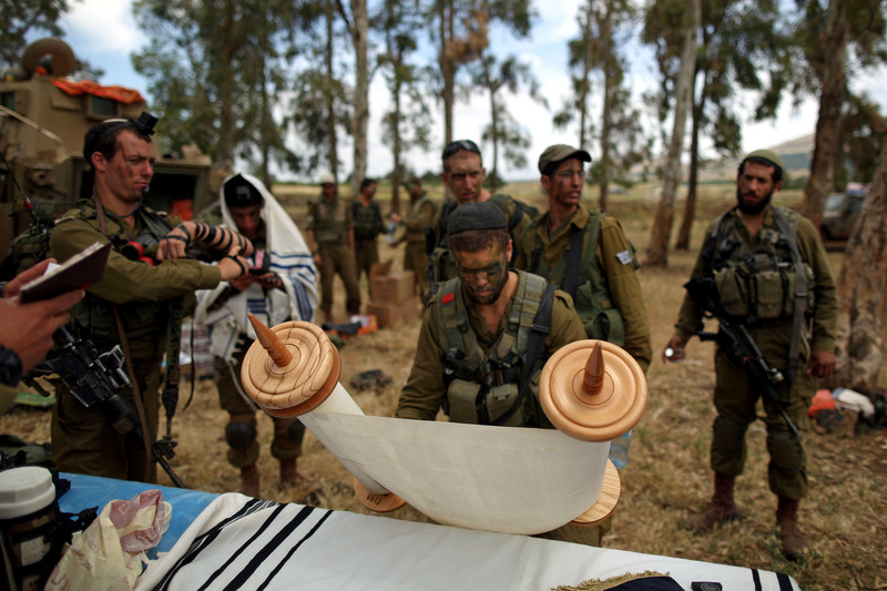 File: An Israeli soldier from the Netzach Yehuda brigade, the Israeli army battalion for Orthodox soldiers and Yeshiva students, opens a Torah scroll during the battalion ground maneuver exercise in the Golan Heights near the Israeli-Syrian border. EPA/ABIR SULTAN