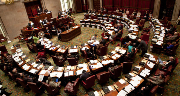 FILE - Members of the New York Senate pass legislative bills in the Senate Chamber at the Capitol in Albany, N.Y. (AP Photo/Hans Pennink)