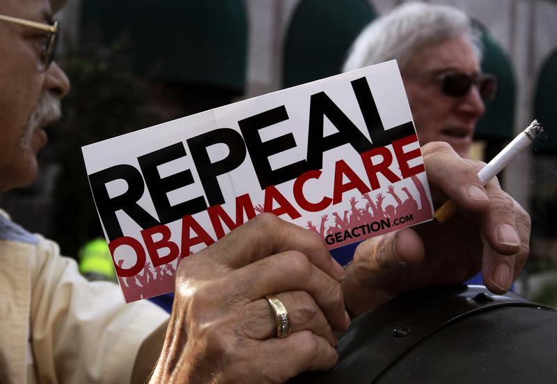 FILE - A small group of demonstrators stand outside of of a hotel before former South Carolina Senator Jim DeMint, president of the The Heritage Foundation, speaks at a "Defund Obamacare Tour" rally in Indianapolis, Indiana, U.S. August 26, 2013. REUTERS/Nate Chute/File Photo