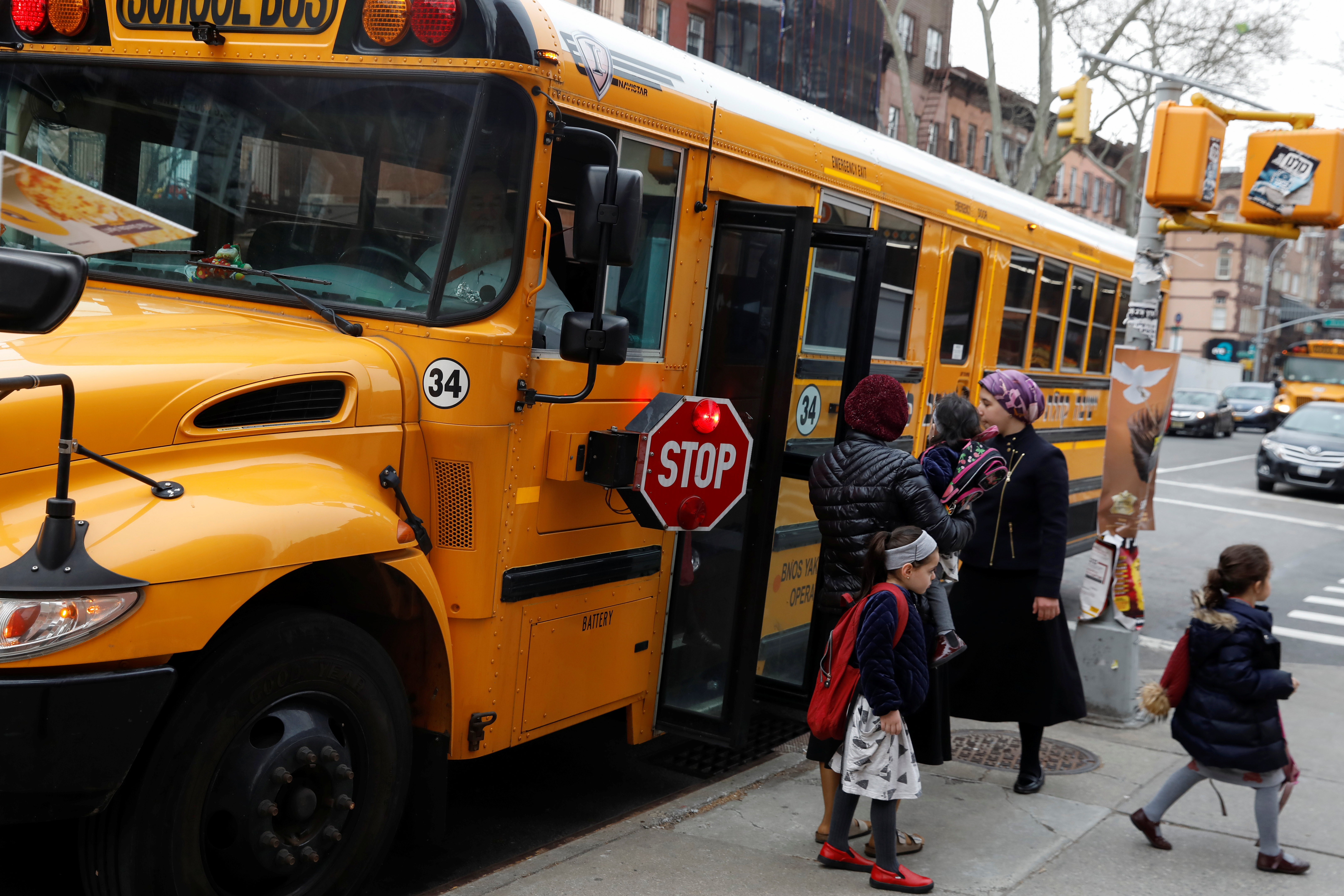 Orthodox Jewish children get off a Yeshiva school bus, as New York City Mayor Bill de Blasio declared a public health emergency in parts of Brooklyn in response to a measles outbreak, in the Williamsburg neighborhood of Brooklyn in New York City, U.S., April 9, 2019. REUTERS/Shannon Stapleton