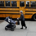 An Orthodox Jewish woman walks by a Yeshiva school bus on the day New York City Mayor Bill de Blasio declared a public health emergency in response to a measles outbreak, in the Orthodox Jewish community of the Williamsburg neighborhood of Brooklyn in New York City, U.S., April 9, 2019. REUTERS/Shannon Stapleton