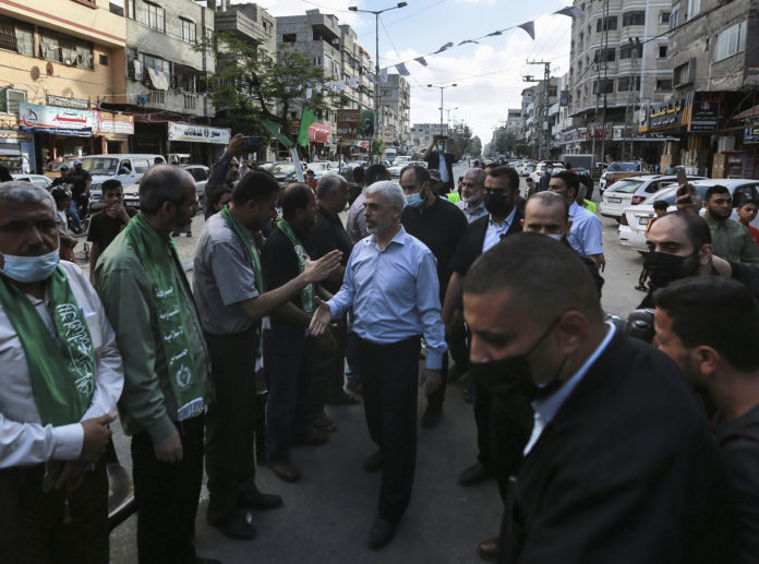 Top Hamas leader in Gaza, Yehiyeh Sinwar, center, pays his respects at a house of mourning for a Hamas commander killed in the war, in Gaza City, Saturday, May 22, 2021. Sinwar, made his first public appearance since the militant group's war with Israel erupted earlier this month. (AP Photo/Mohammed Mohammed)