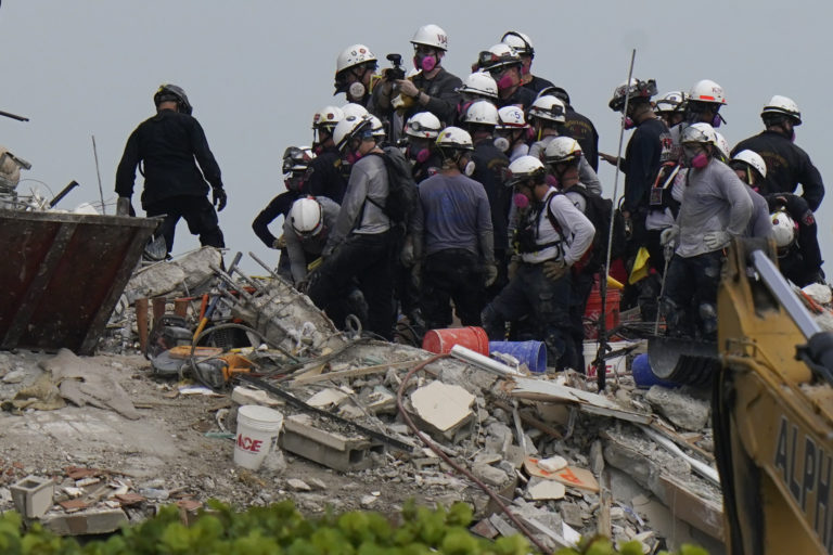 Search and rescue personnel work atop the rubble at the Champlain Towers South condo building, where scores of people remain missing almost a week after it partially collapsed, Wednesday, June 30, 2021, in Surfside, Fla. (AP Photo/Lynne Sladky)