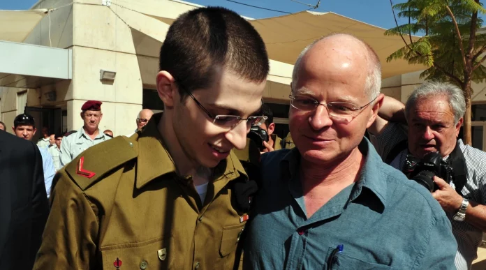 In this handout photo provided by the Israel Defenses Force, freed Israeli soldier Gilad Shalit (L) walks with his father Noam Shalit at Tel Nof Airbase, Oct. 18, 2011. (Israel Defense Forces via Getty Images)