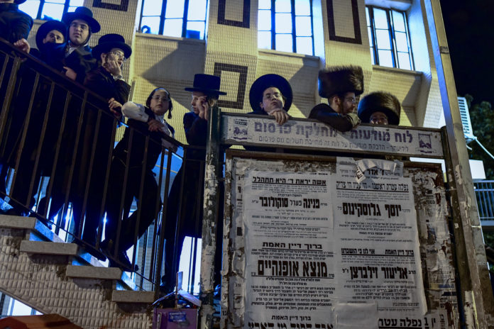 People gather outside the home of Rabbi Chaim Kanievsky who passed away, in the city of Bnei Brak, on March 19, 2022. Photo by Avshalom Sassoni/ Flash90 *** Local Caption ***