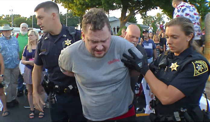 In this image taken from video provided by WHEC-TV, David Jakubonis, center, is taken into custody by Monroe County Sheriff deputies after he brandished a sharp object during an attack on U.S. Rep. Lee Zeldin, as the Republican candidate for New York governor delivered a speech in Perinton, N.Y., Thursday, July 21, 2022. Jakubonis, 43, has been charged with attempted assault, arraigned and released, a Monroe County sheriff's spokesperson said. (WHEC-TV via AP)