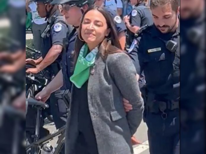 WATCH: AOC and Vicious Omar Pretend to be Handcuffed, Video Shows They’re Faking
