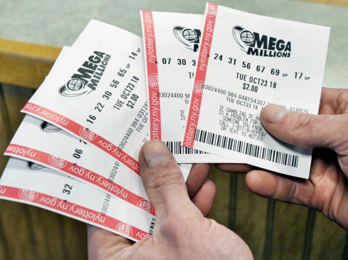 Adam Gerling of Albany checks his Mega Millions tickets at Edleez Tobacco in Stuyvesant Plaza Tuesday Oct. 23, 2018 in Albany, NY. (John Carl D'Annibale/Times Union)